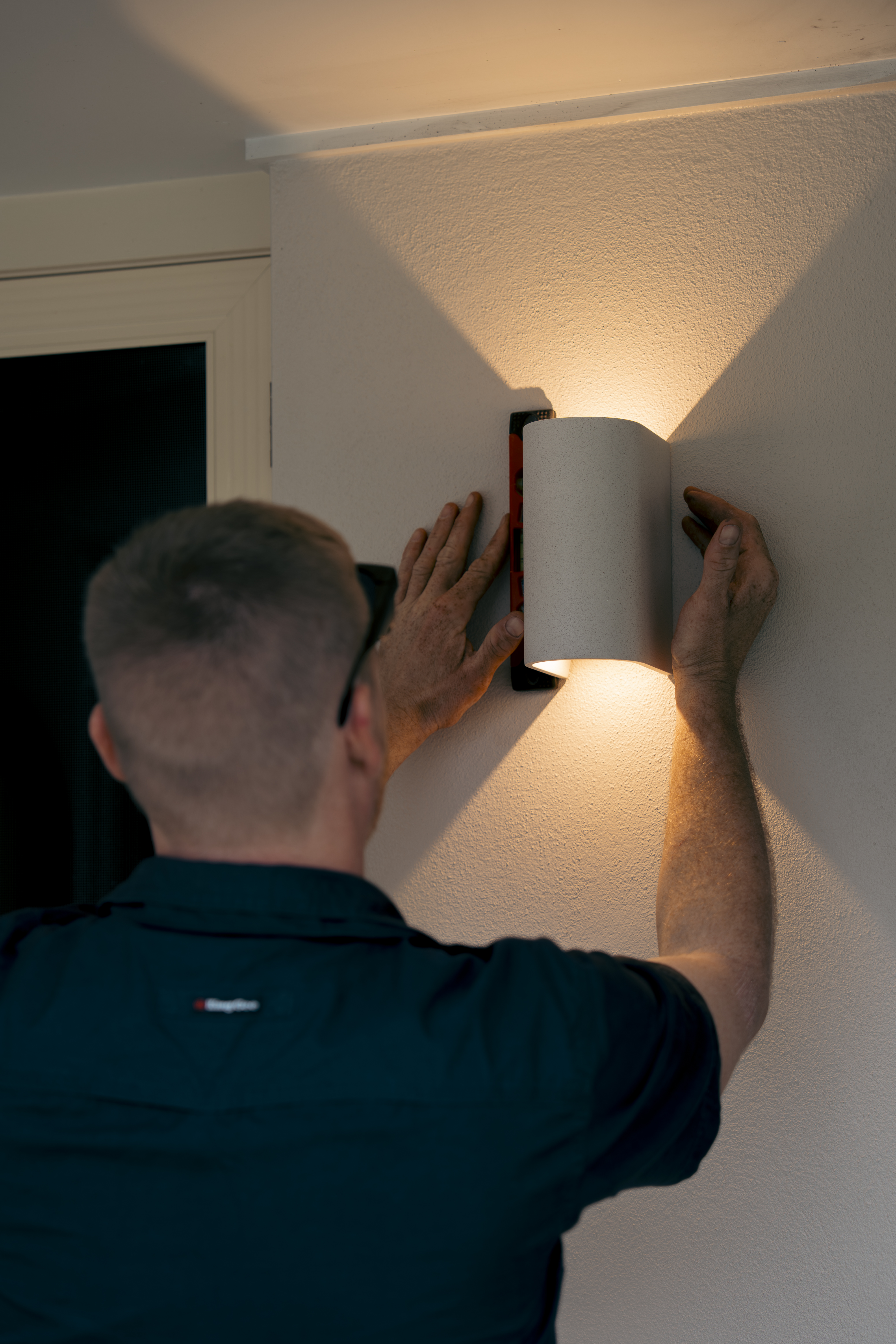 Electrician installing wall light